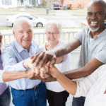 Smiling older adults with their hands in a circle