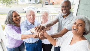 Smiling older adults with their hands in a circle