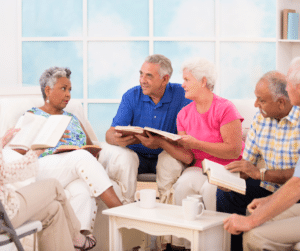 older adults sit in a semi-circle discussing a book